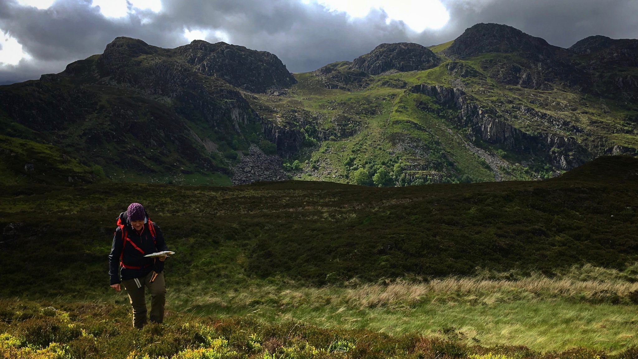 A client practices her map reading off tracks in a remote part of Snowdonia during a mountain navigation course” width=