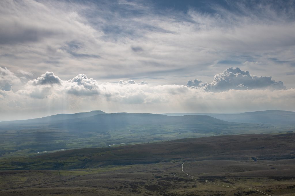 A dramatic view across the Yorkshire Dales from pen y Ghent to Ingleborough with light breaking through some storm clouds