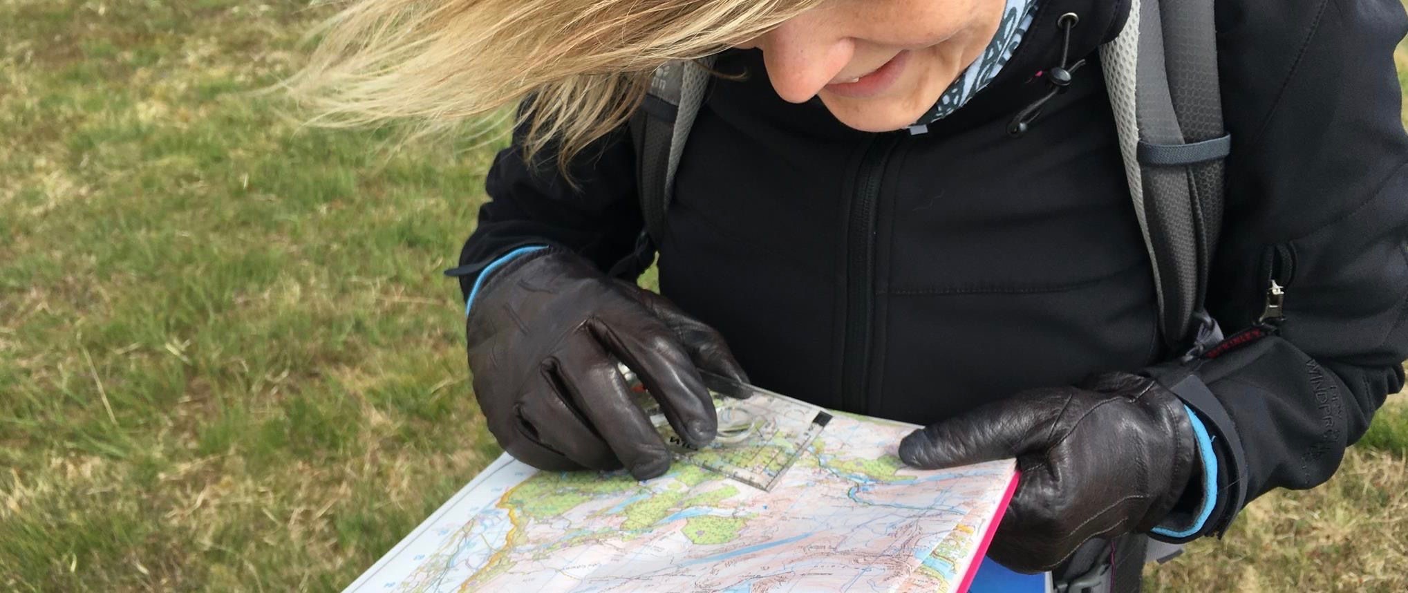 A student checks their map and compass on a beginners' navigation course