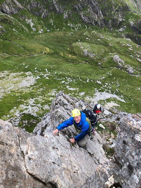 A climber smiles while enjoying the views on the Cneifion Arete in Snowdonia
