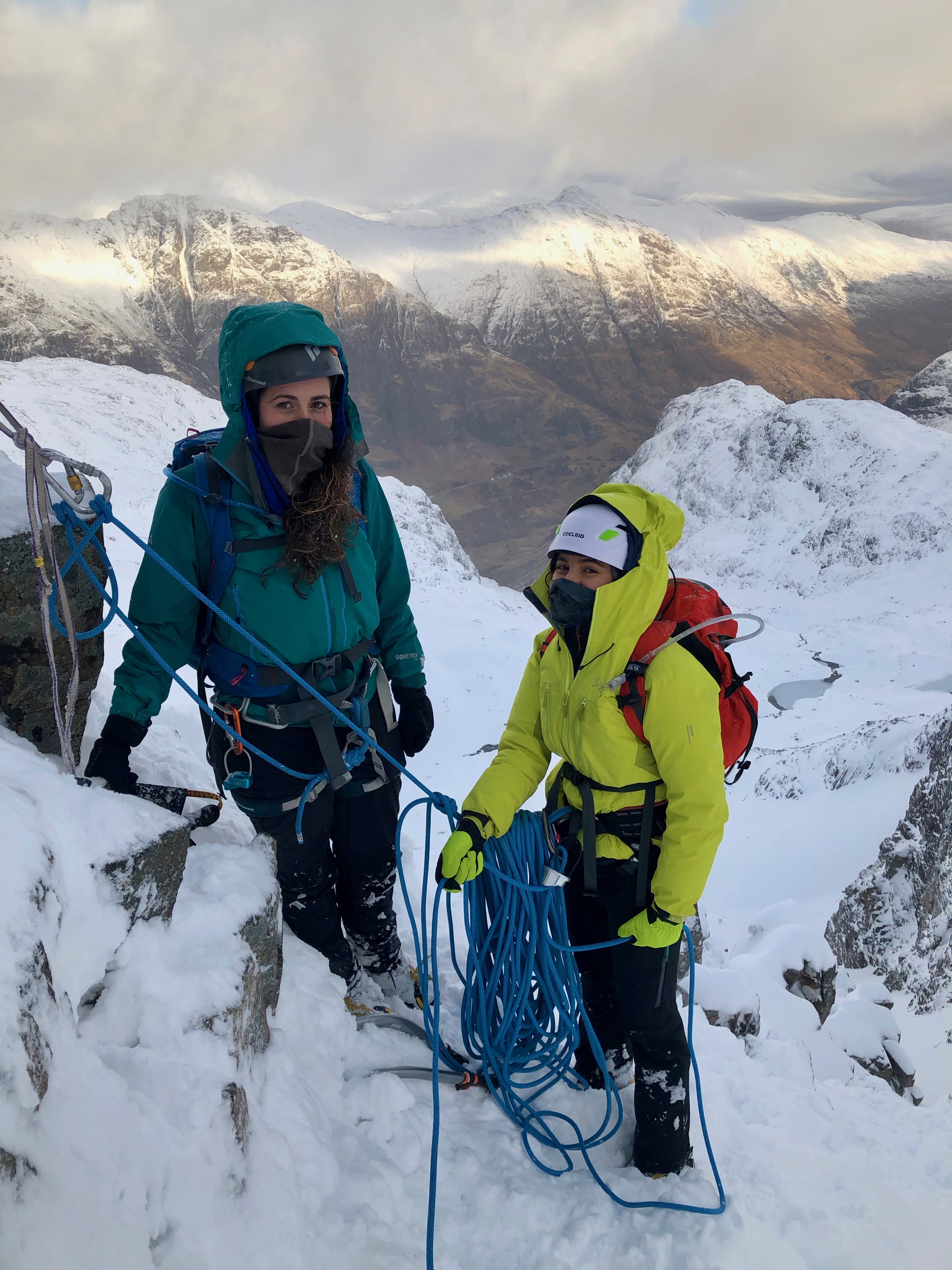 Two climbers at a belay stance high up on Dorsal Arete in Glencoe on a winter mountaineering course