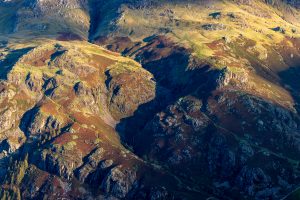 A close up of the line of Dungeon Ghyll in the Langdale Pikes in the Lake District seen in the early morning sunlight