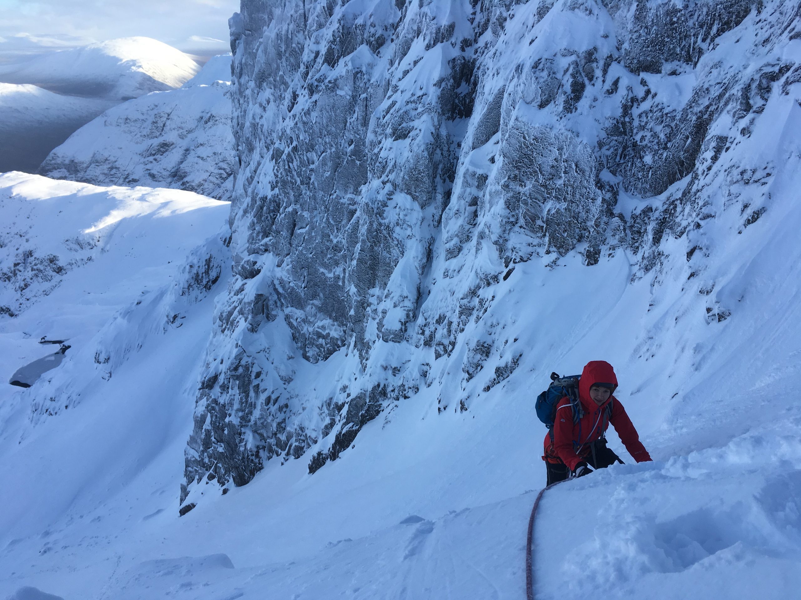 A climber in deep snow beginning the first pitch of Dorsal Arete in Glencoe during a winter mountaineering course