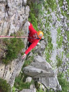 A climber has almost reached his leader's belay while climbing on Milestone Buttress in Snowdonia during a rock climbing course