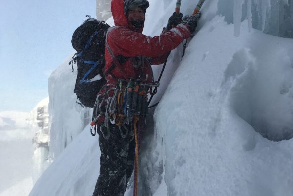 A climber battles spindrift to set off on the second pitch of Quartzvein Scoop