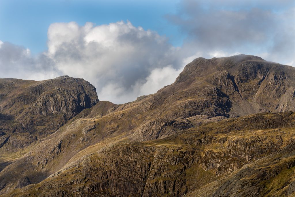A close up of the cliffs of Scafell, with the col or saddle of Mickledore and Scafell Pike also visible on the right during a guided walk