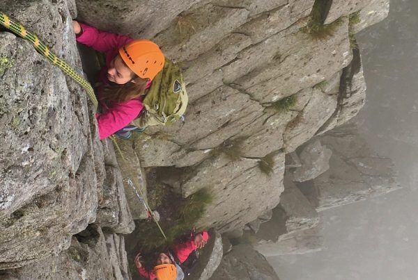 Two climbers tackling the difficult corner pitch high up on the Dolmen Ridge on Glyder Fach during an advanced scrambling course in Snowdonia