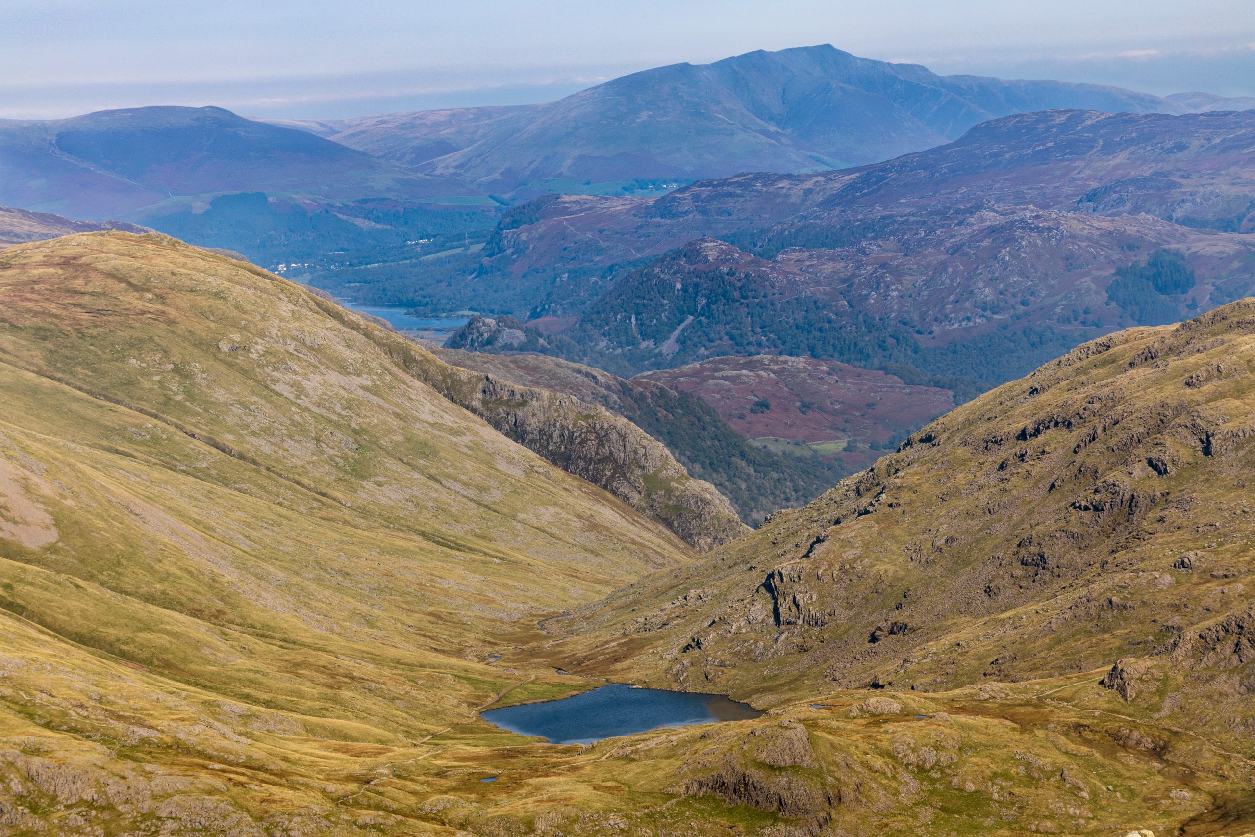 Looking over Styhead Tarn with Derwent Water and Blencathra visible in the distance