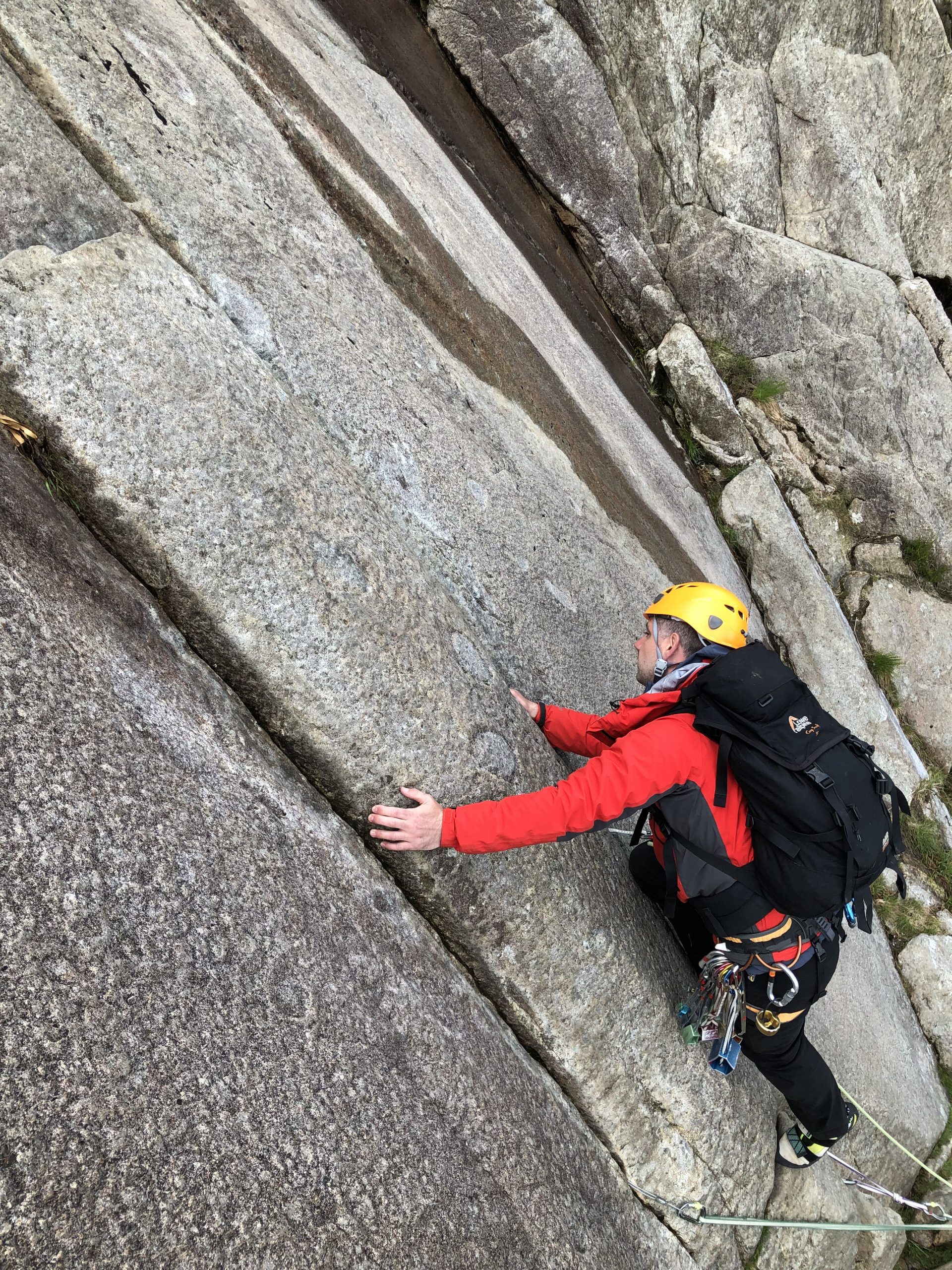 A climber working out his next move on the famous 'Twin Cracks' on Hope, a multi-pitch rock climb on Idwal Slabs in Snowdonia, during a multi-pitch climbing course