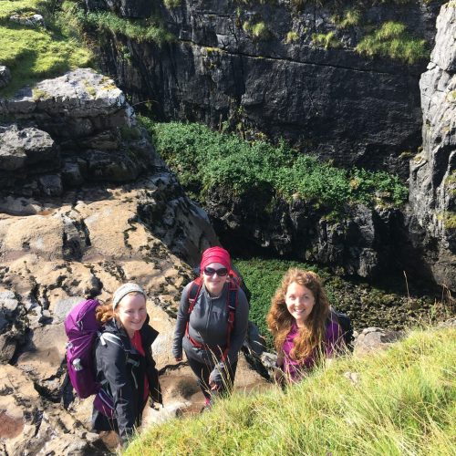 Three ladies explore the sides of Hull Pot in the Yorkshire Dales during a guided Yorkshire Three Peaks walk