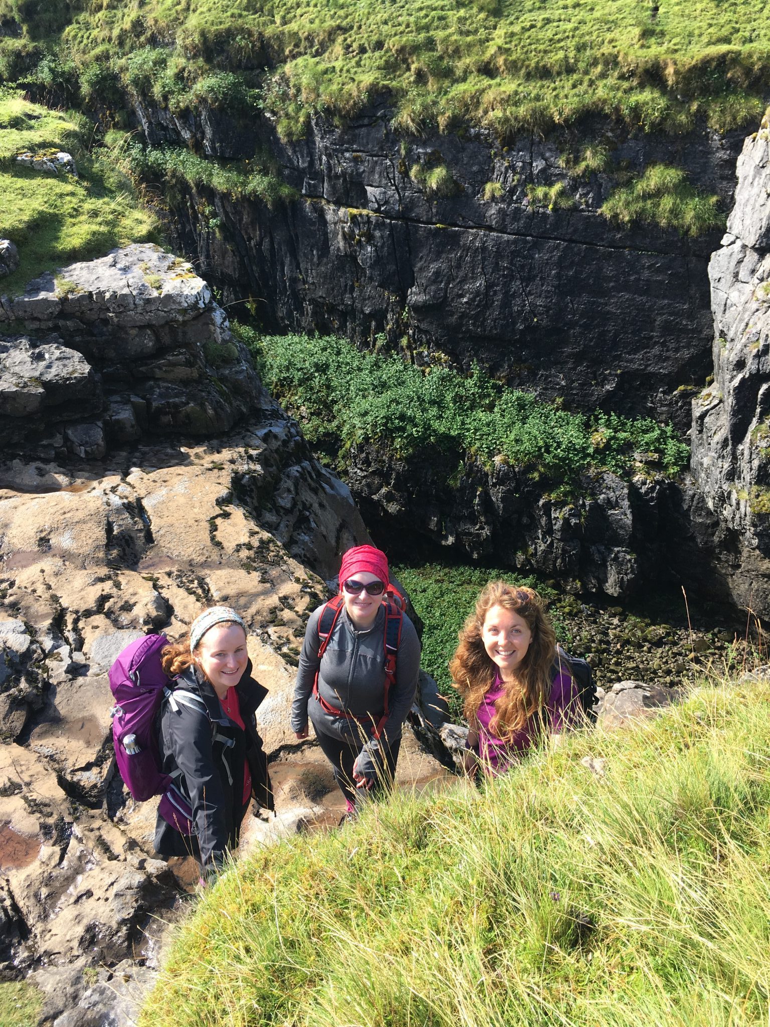 Three ladies explore the sides of Hull Pot in the Yorkshire Dales during a guided Yorkshire Three Peaks walk